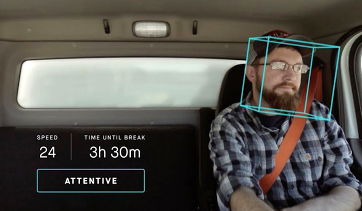 Truck driver at the wheel with AI data showing his attentiveness, speed, and time til break.