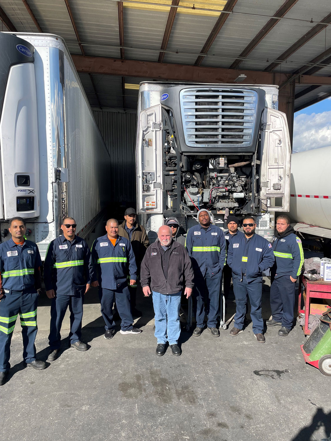 TCI group shot of entire team in front of 3 reefers.