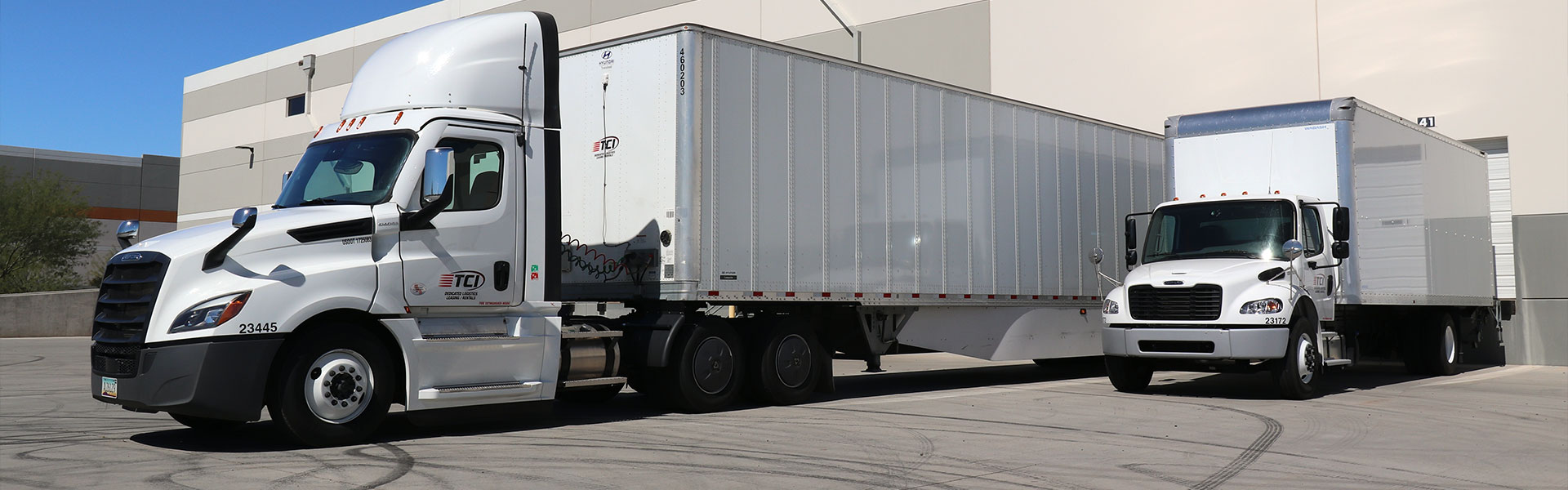 A tractor trailor and a boc truck in a loading area