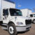 Row of a variety of white box trucks.