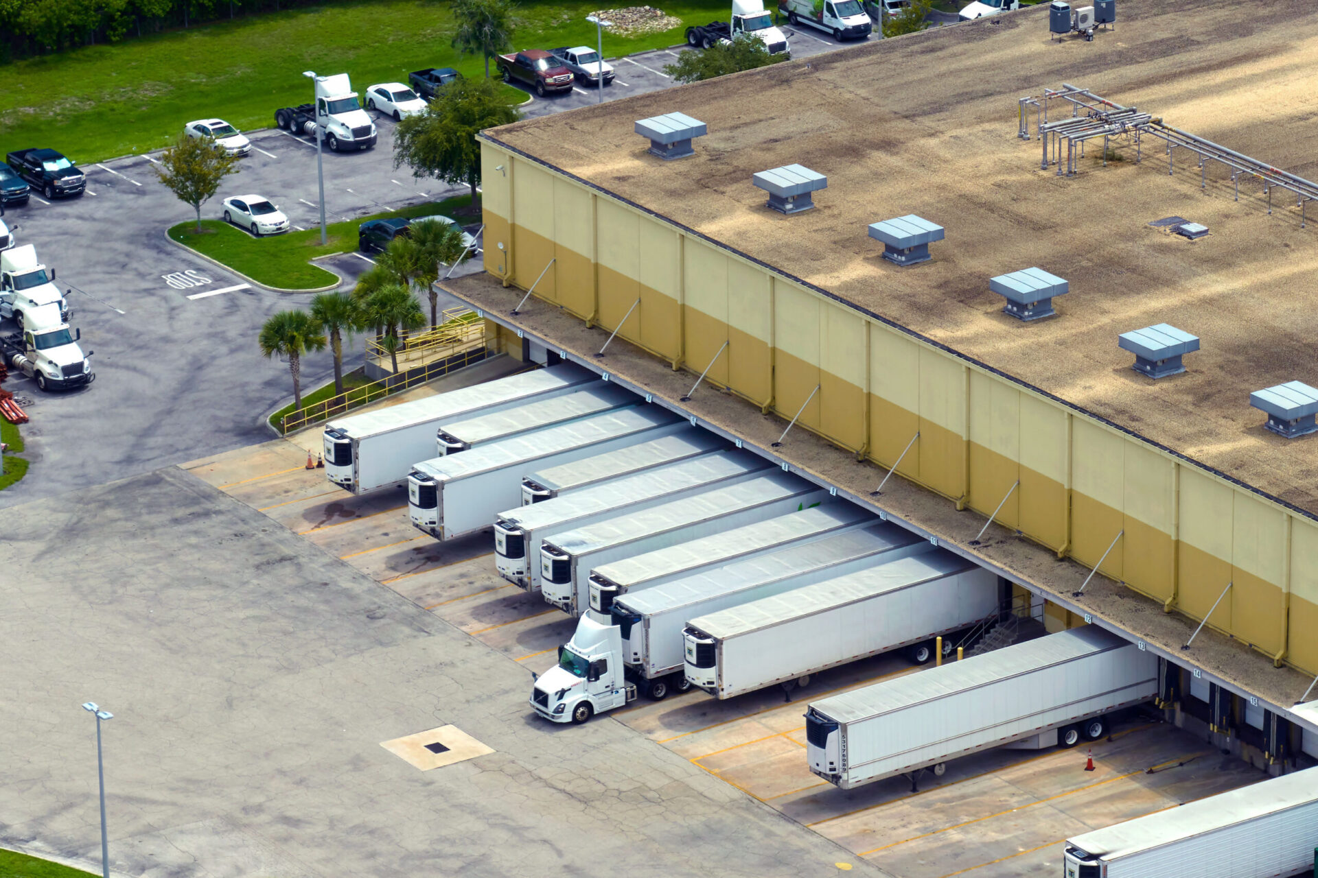 Overhead view of warehouse with trucks and containers at loading bays.